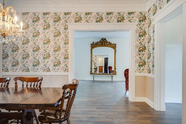 dining area with crown molding, dark hardwood / wood-style floors, and a notable chandelier