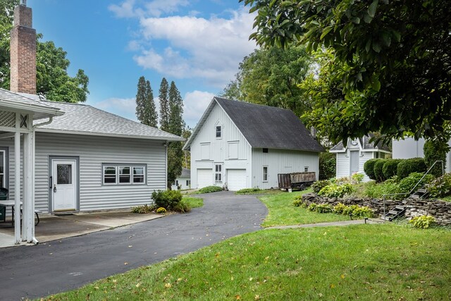 exterior space featuring an outbuilding, a garage, and a lawn