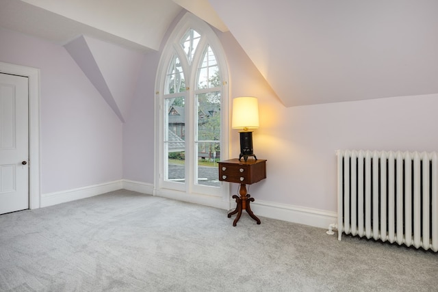 bonus room featuring light colored carpet, radiator, vaulted ceiling, and a wealth of natural light