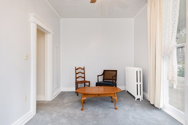 living area featuring crown molding, carpet floors, radiator heating unit, and ceiling fan