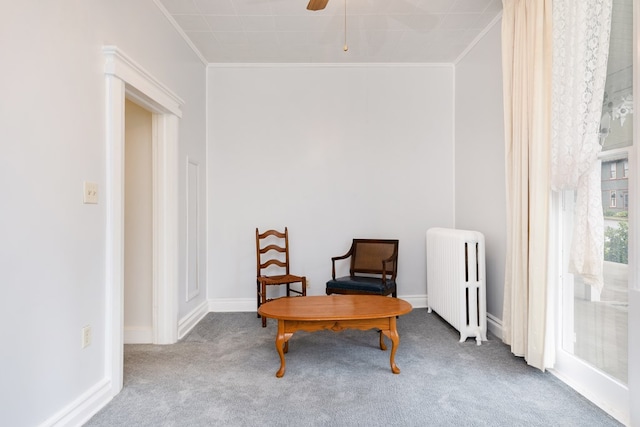 sitting room featuring crown molding, ceiling fan, radiator, and carpet floors