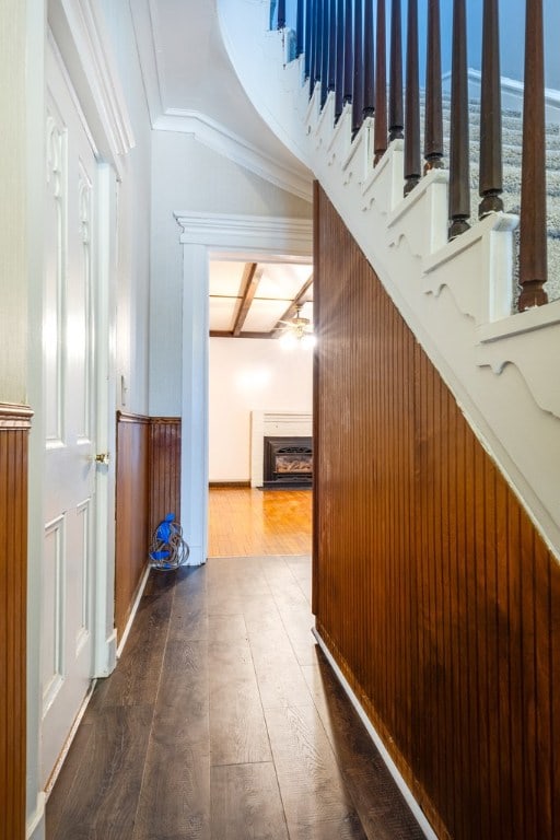 corridor featuring crown molding, hardwood / wood-style flooring, and beamed ceiling