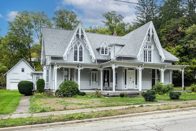 victorian-style house featuring a front lawn and a porch