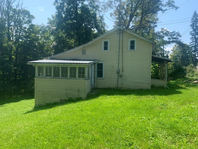 rear view of property featuring a lawn