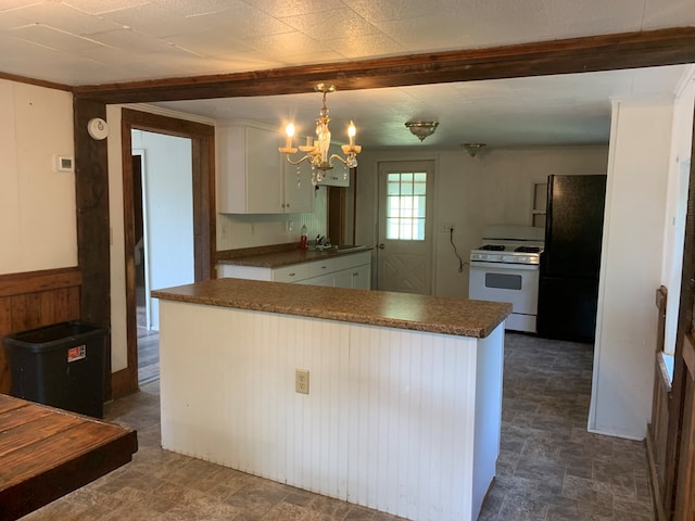 kitchen featuring decorative light fixtures, white cabinets, kitchen peninsula, black fridge, and white gas stove