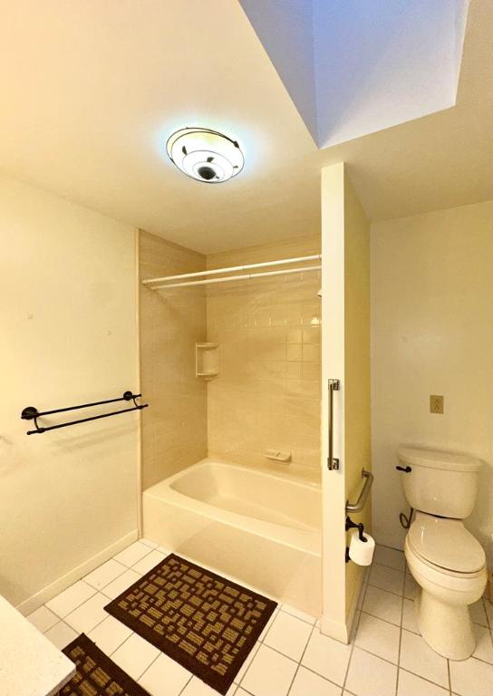 bathroom featuring tiled shower / bath, tile patterned floors, and toilet