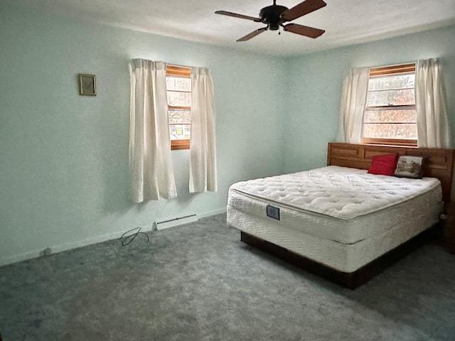 carpeted bedroom featuring multiple windows, a baseboard radiator, and ceiling fan