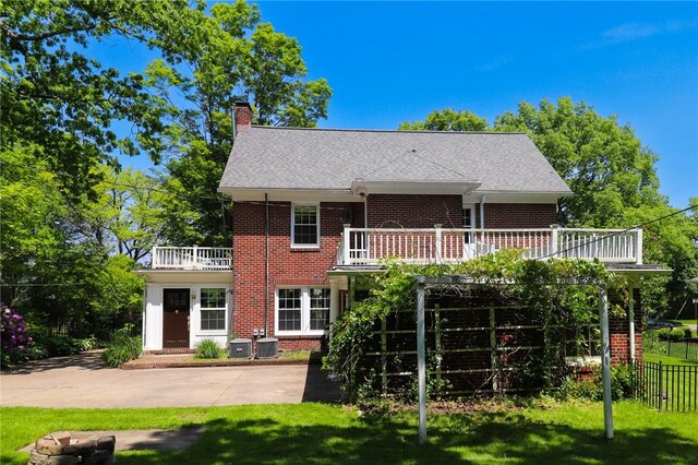 188 Upper Delevan Ave, Corning-City, NY 14830 - rear view of house with brick siding, a chimney, a balcony, and central AC unit