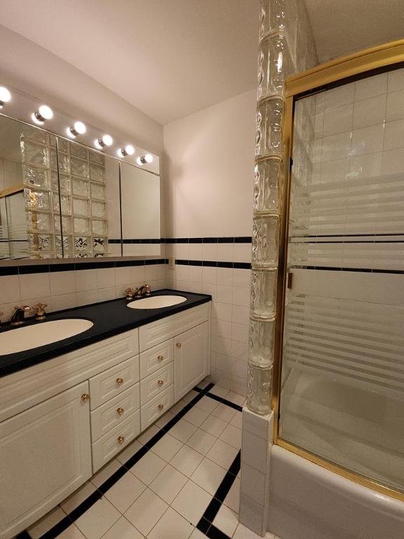 bathroom featuring tile walls, vanity, tile patterned flooring, and enclosed tub / shower combo