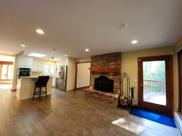 living room with sink, a fireplace, and hardwood / wood-style floors