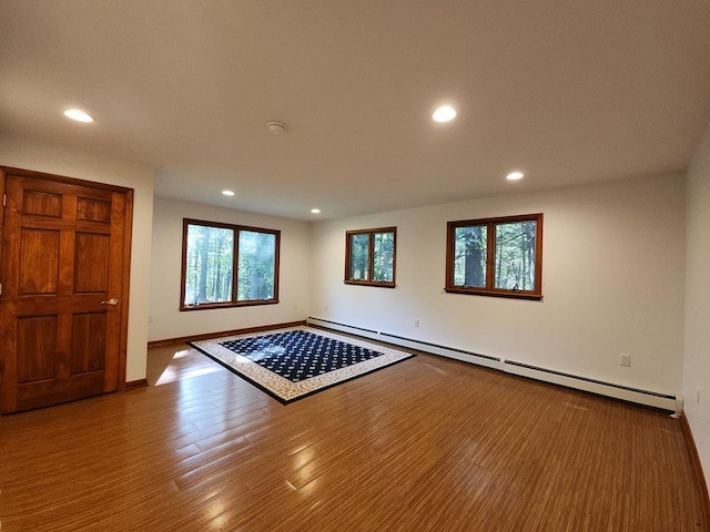 interior space with a baseboard radiator and hardwood / wood-style floors