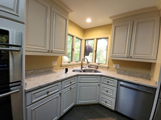 kitchen with sink, stainless steel appliances, white cabinets, and light stone countertops