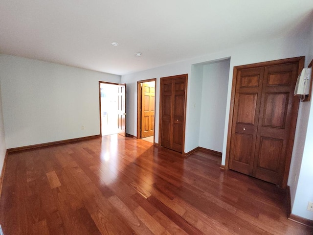 unfurnished bedroom with dark wood-type flooring