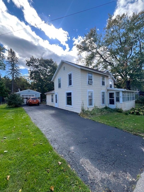 view of side of property featuring a sunroom and a lawn