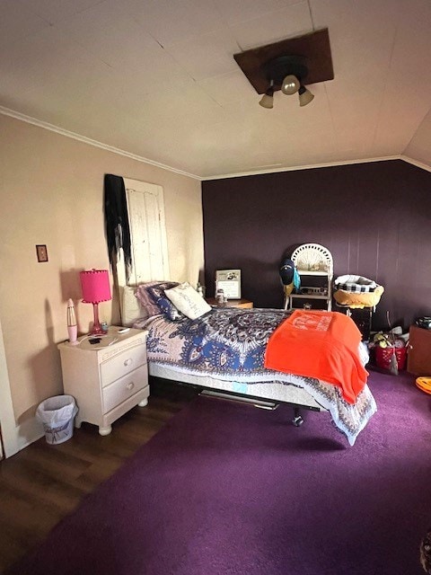 bedroom with crown molding, wood-type flooring, and vaulted ceiling