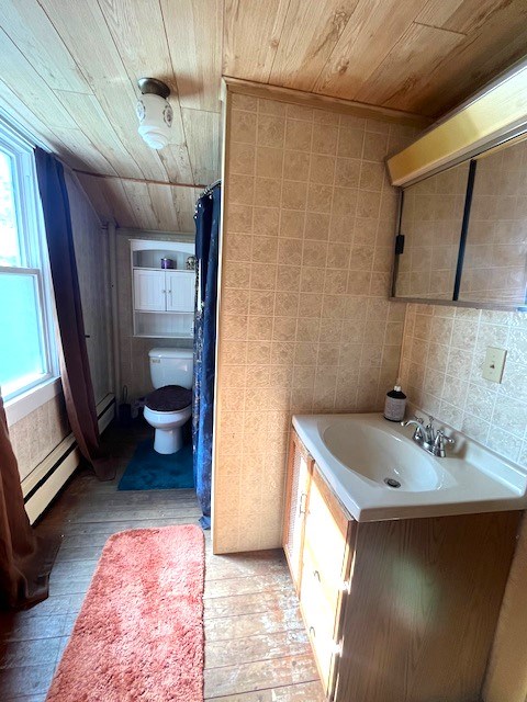 bathroom with tile walls, a baseboard heating unit, wood ceiling, and vanity