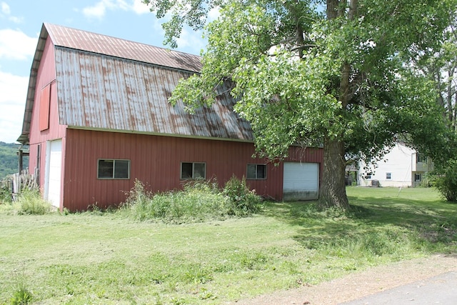 view of home's exterior with a garage, an outdoor structure, and a lawn