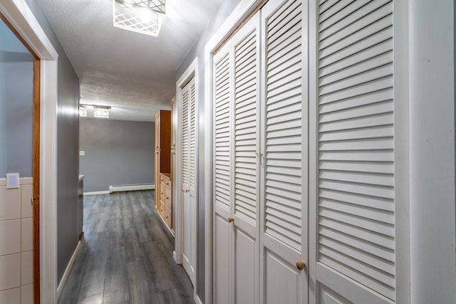 corridor featuring dark hardwood / wood-style flooring, a textured ceiling, and baseboard heating