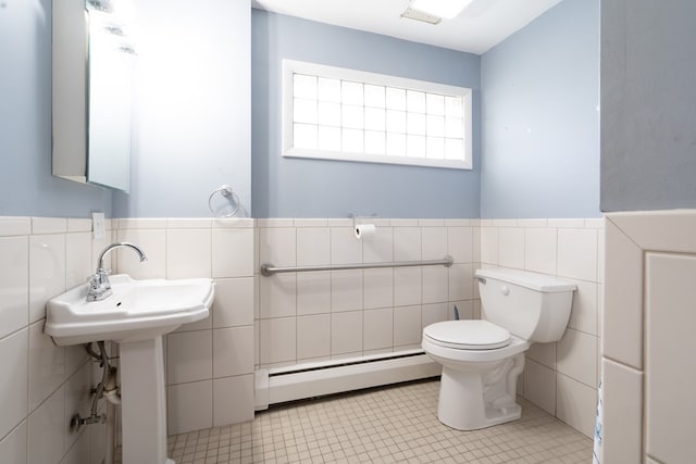 bathroom with a baseboard radiator, tile walls, tile patterned floors, and toilet