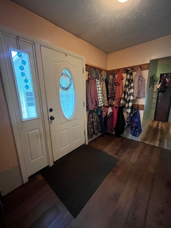 entryway with dark wood-type flooring and a textured ceiling