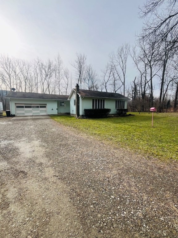 ranch-style home with a garage and a front lawn