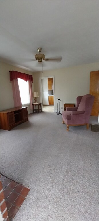 living room featuring ceiling fan and carpet floors