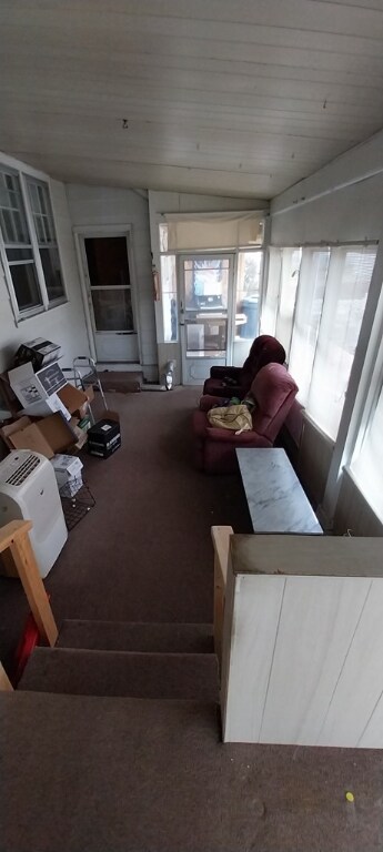 carpeted living room featuring wood ceiling