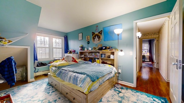 bedroom with a baseboard radiator and wood-type flooring