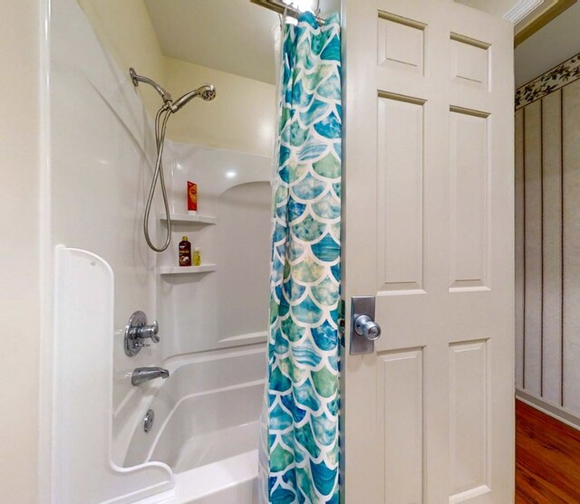 bathroom with shower / tub combo with curtain and hardwood / wood-style flooring