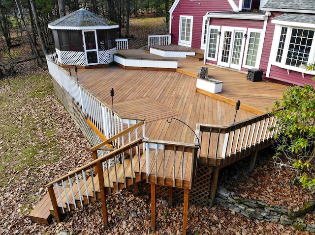 wooden terrace with a gazebo, central air condition unit, a sunroom, and french doors