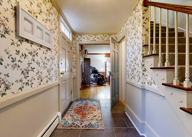 hall featuring a baseboard heating unit, crown molding, and dark tile patterned floors