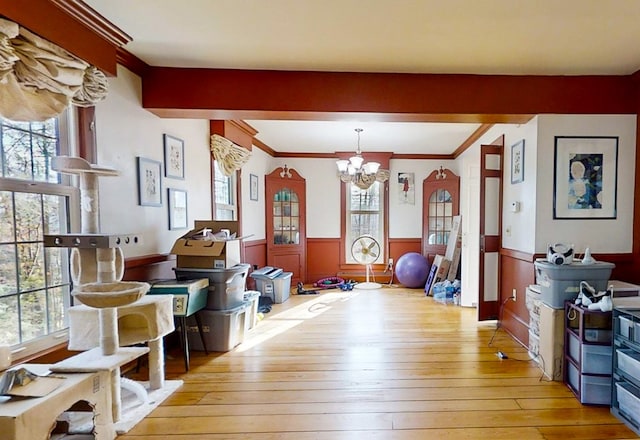 interior space with ornamental molding, a chandelier, and light hardwood / wood-style floors