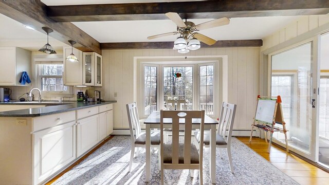 interior space featuring light hardwood / wood-style flooring, sink, plenty of natural light, and beamed ceiling