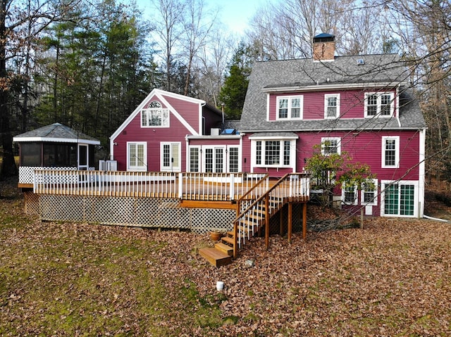 back of property with a wooden deck and a sunroom