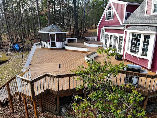 wooden terrace with a gazebo and a sunroom