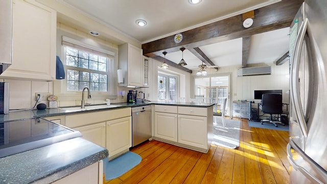 kitchen with sink, light hardwood / wood-style flooring, appliances with stainless steel finishes, a wall mounted AC, and kitchen peninsula