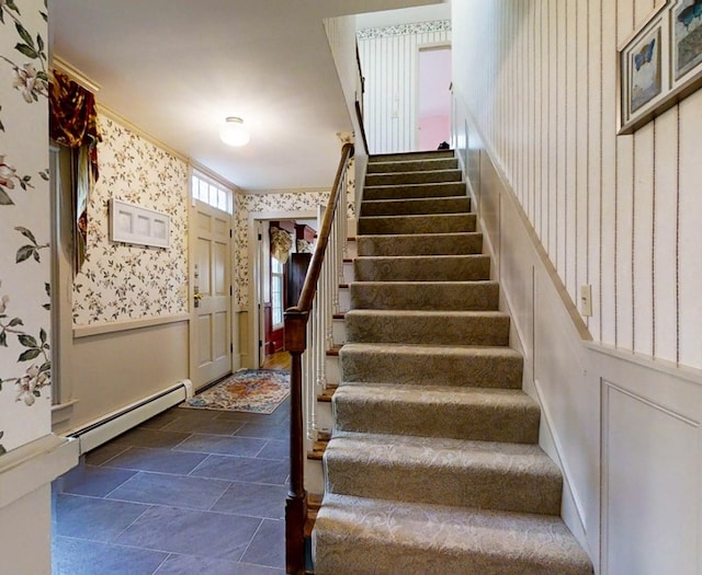 stairway with a baseboard radiator and crown molding