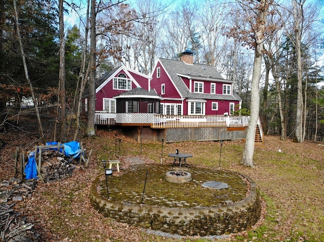 back of property with a wooden deck, a fire pit, and a gazebo