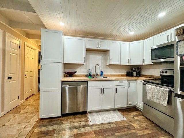 kitchen featuring white cabinetry, stainless steel appliances, backsplash, and sink