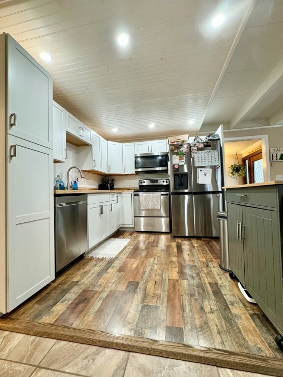 kitchen featuring white cabinetry, appliances with stainless steel finishes, sink, and hardwood / wood-style floors