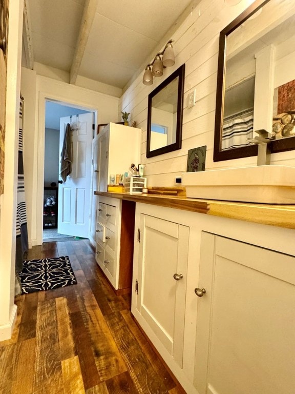 bathroom with beamed ceiling, vanity, hardwood / wood-style floors, and wooden walls