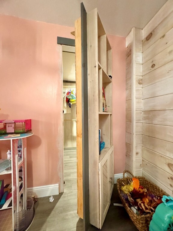 bathroom with hardwood / wood-style floors and wood walls