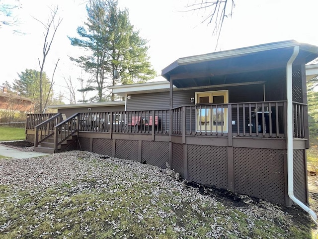 rear view of house featuring a wooden deck