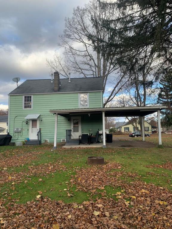 back of property with a patio and a lawn