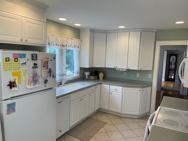 kitchen featuring sink, white appliances, white cabinets, and light tile patterned flooring