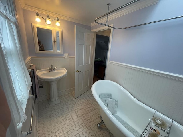 bathroom with crown molding and a tub