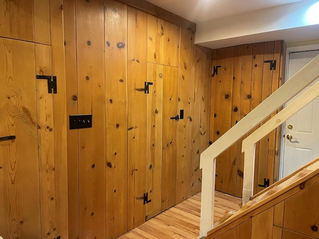 interior space with hardwood / wood-style flooring and wood walls