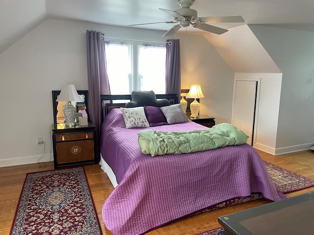 bedroom with hardwood / wood-style flooring, vaulted ceiling, and ceiling fan