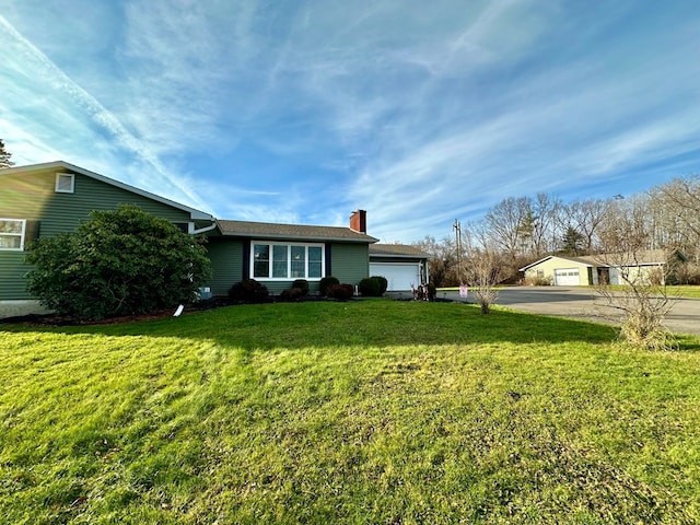 view of front of home with a garage and a front lawn