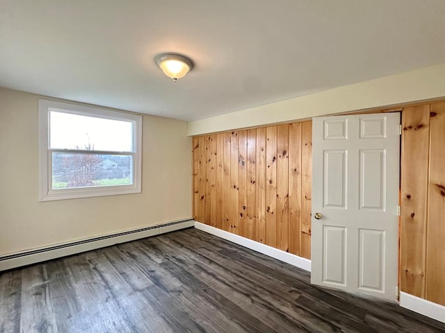 empty room featuring a baseboard radiator and dark wood-type flooring